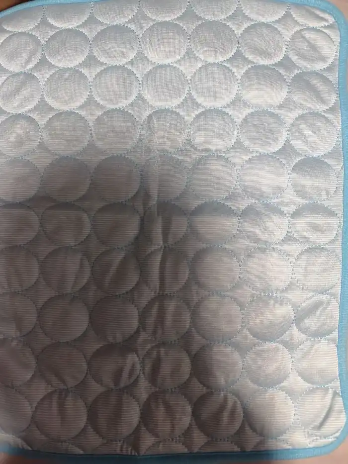 Hellblaue Kühlmatte aus der Nähe fotografiert, die gesteppte Oberfläche ist zu sehen